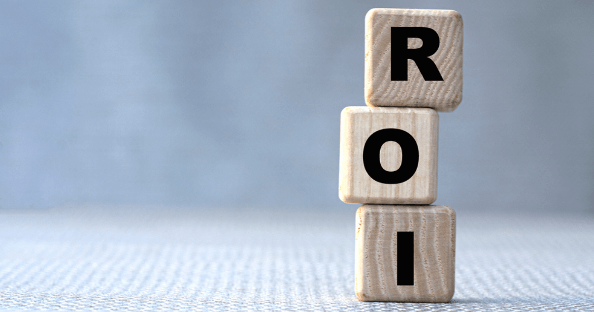palabra ROI (Retorno de la inversión) en cubos de madera sobre un fondo gris.