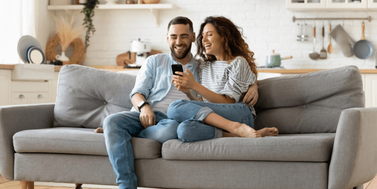 pareja feliz haciendo una compra a través de la aplicación móvil