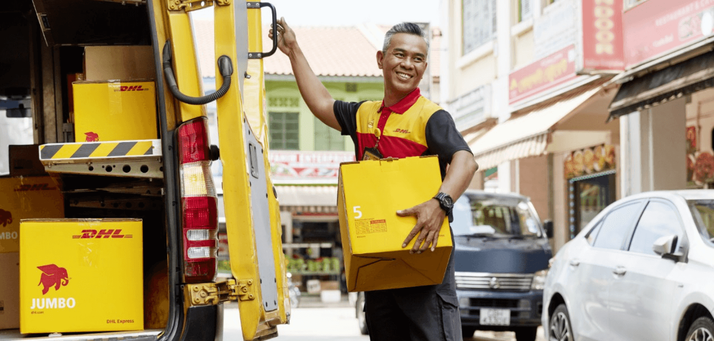 Courier de DHL entregando los paquetes de logística internacional